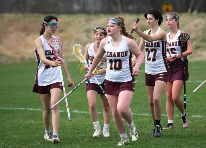 Lebanon teammates, from left, Angela MacDonald, Norah Burns, Lucy Eshbaugh, Eden Ames, and Abigail Ripley, celebrate as they leave the field after their 8-3 win over Coe-Brown in Lebanon, N.H., on Friday, April 19, 2024. (Valley News - James M. Patterson) Copyright Valley News. May not be reprinted or used online without permission. Send requests to permission@vnews.com.