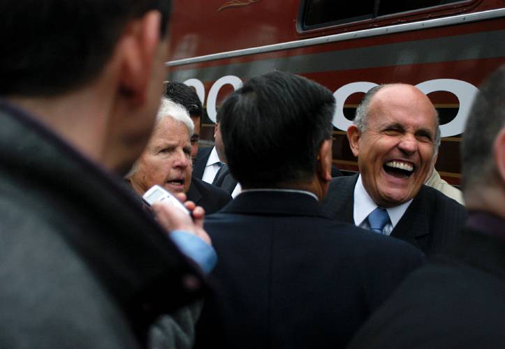 Rudy Giuliani laughs while talking with Winifred Stearns of Hanover, N.H., left, during a campaign stop in White River Junction, Vt., on Tuesday, May 23, 2007. Stearns got a bear hug from the Republican presidential candidate while giving him a copy of a New York Times column that said his popularity among GOP voters signaled the 