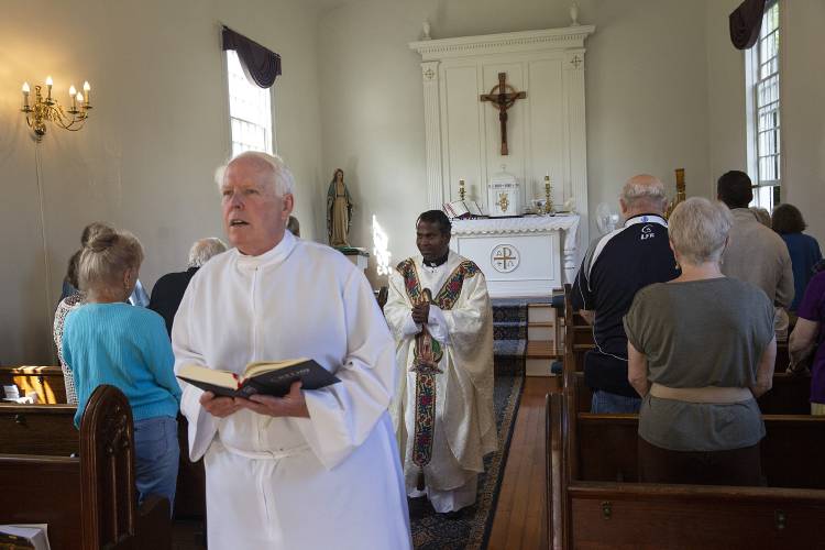 Sacristan Kevin Krawiec, left, and the Rev. Sebastian Susairaj process out at the conclusion of Mass at Old St. Mary Church in Claremont, N.H., on Saturday, August 26, 2023. The church, which is the oldest Roman Catholic church in New Hampshire, is celebrating its 200th anniversary this year. (Valley News / Report For America - Alex Driehaus) Copyright Valley News. May not be reprinted or used online without permission. Send requests to permission@vnews.com.