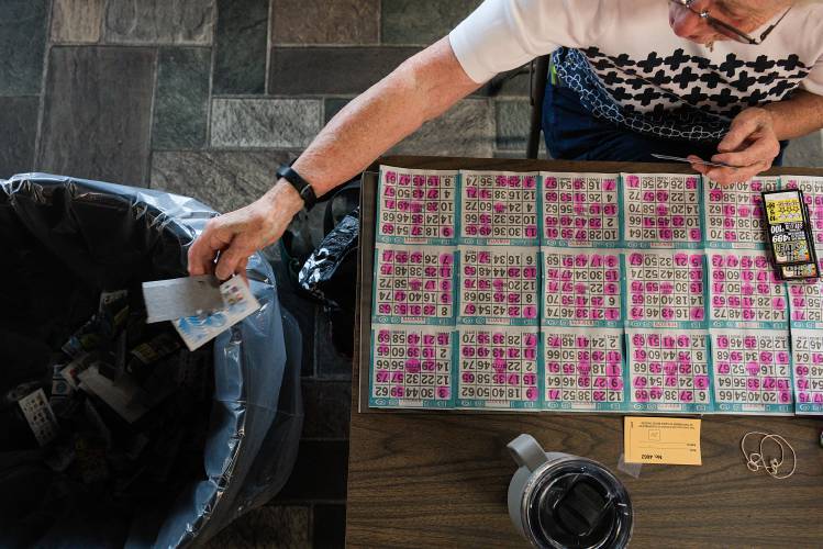 Mary Davis, of Lebanon, throws out non-winning pull tickets while preparing for bingo at the LaSalette Shrine in Enfield, N.H., on Tuesday, August 1, 2023. The games, costing between a quarter to $5 per ticket, and with guaranteed winners in each box, bring in more money than the actual bingo games. (Valley News - James M. Patterson) Copyright Valley News. May not be reprinted or used online without permission. Send requests to permission@vnews.com.