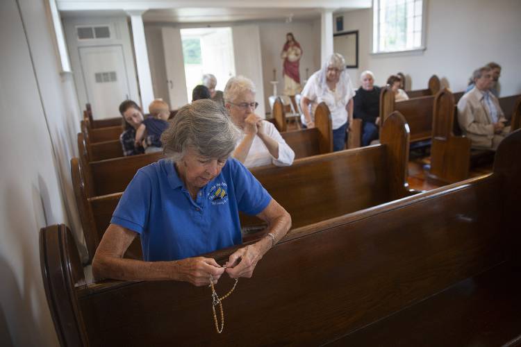 Mary Jane Dietz, left, of Claremont, N.H., prays the rosary before Mass at Old St. Mary Church in Claremont on Saturday, August 26, 2023. The parish primarily holds Mass in its church building on Central Street, but from June through October Masses are held in the smaller Old Church Road chapel on Saturday mornings. (Valley News / Report For America - Alex Driehaus) Copyright Valley News. May not be reprinted or used online without permission. Send requests to permission@vnews.com.