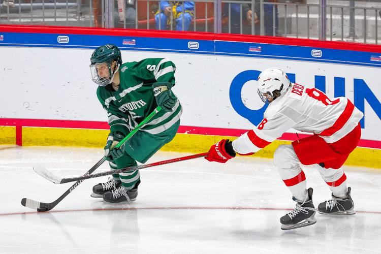 Dartmouth College's Matt Fusco, left, escapes Cornell's Luke Devlin during the ECAC teams' March 22, 2024 playoff semifinal game at Herb Brooks Arena in Lake Placid, N.Y. Cornell won, 6-3. (Valley News - Tris Wykes) Copyright Valley News. May not be reprinted or used online without permission. 