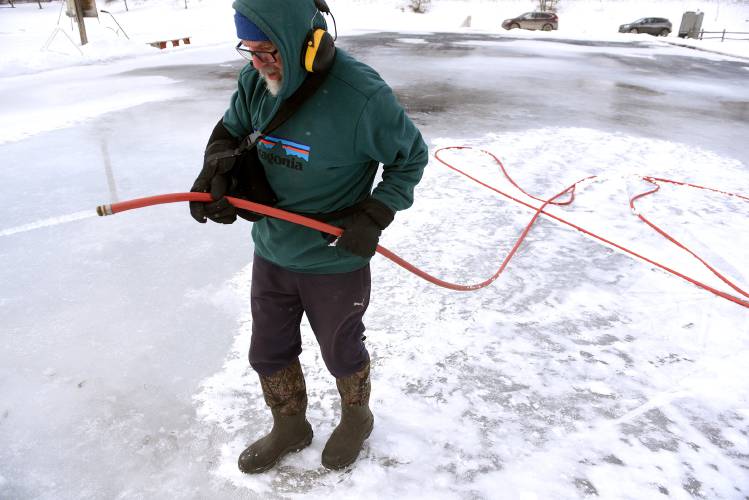 Peter Amber, of Chelsea, Vt., floods the town ice rink in Chelsea, Vt., on Wednesday, Feb. 14, 2024. Amber has worked on the rink for years, with his family. He said this has been a bad ice year, with recent warm temperatures taking out about one-third of the ice at the rink. 