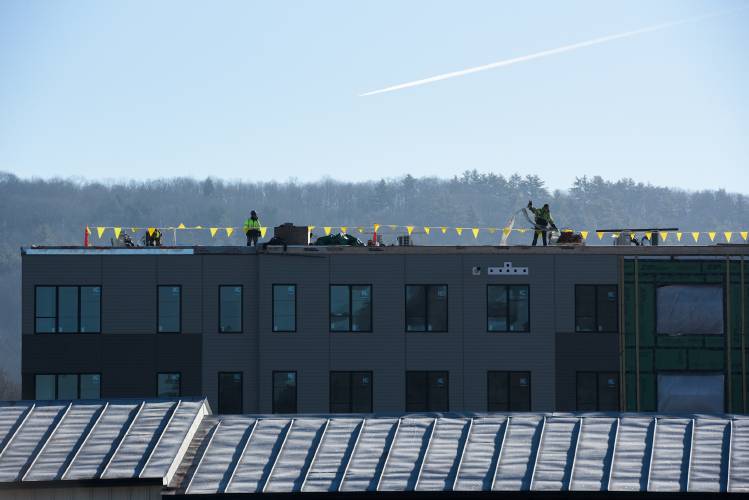 Contracotrs work on the roof of Riverwalk Apartments, a 42 unit mixed income housing building in White River Junction, Vt., on Wednesday, Feb. 21, 2024. The project, a collaboration between construction manager and housing developer DEW-Braverman group and non-profit housing organizations Twin Pines and Evernorth, is expected to be complete by early May. (Valley News - James M. Patterson) Copyright Valley News. May not be reprinted or used online without permission. Send requests to permission@vnews.com.