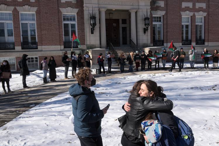 Dartmouth College senior Solange Acosta, right, hugs junior Roan Wade as she prepares to announce the start of a hunger strike with senior Calvin George, left, and six other students at a rally in front of Dartmouth College's Parkhurst Hall in Hanover, N.H., on Monday, Feb. 19, 2024. Wade said that in light of death threats she has received since being arrested while demonstrating on the administration building's lawn last October, she feels that undertaking a hunger strike for a cause she believes in gives her control over the risks she is facing. (Valley News - James M. Patterson) Copyright Valley News. May not be reprinted or used online without permission. Send requests to permission@vnews.com.