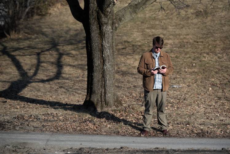 Charlie Clark, of West Lebanon, reads while waiting for the bus in West Lebanon, N.H., on Tuesday, Feb. 27, 2024. (Valley News - James M. Patterson) Copyright Valley News. May not be reprinted or used online without permission. Send requests to permission@vnews.com.