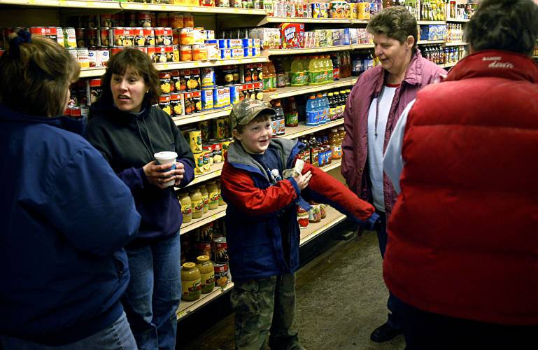Grocery shopping at Coburns' General Store in South Strafford, Vt., on Jan. 22, 2005, turns to social hour in the isles when Deanna Mitchell, left, her son Trevor Mitchell-Litchfield, 7, and her mother Etta Litchfield, second from right, all of Strafford, Vt., run into Chrissy Jamieson, second from left, and Ann Kitchel, of South Strafford, far right. Deanna has worked at the store for five years, and Chrissy, Melvin Coburn's daughter, has worked full time in the store for seven years and on and off since she was 9. (Valley News - James M. Patterson) Copyright Valley News. May not be reprinted or used online without permission. Send requests to permission@vnews.com.