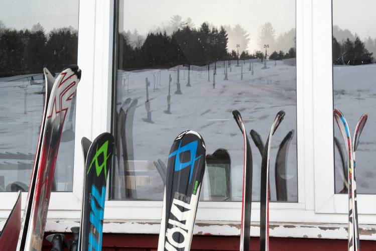 Skis rest against the lodge at Northeast Slopes as snow cover diminishes on a closed day in East Corinth, Vt., on Thursday, Feb. 15, 2024. (Valley News - James M. Patterson) Copyright Valley News. May not be reprinted or used online without permission. Send requests to permission@vnews.com.