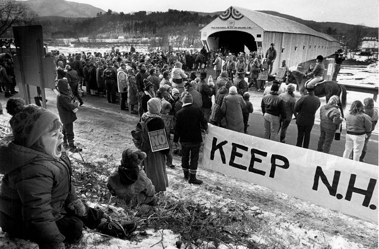Four-year-old David McCumber, of Unity, N.H., would seem to care less about all of the pomp and protests over the reopening of the Cornish-Windsor Covered Bridge in Cornish, N.H., on Dec. 8, 1989. About 1,000 people attended the ceremony for the 122-year-old bridge. (Valley News - Geoff Hansen) Copyright Valley News. May not be reprinted or used online without permission. Send requests to permission@vnews.com.