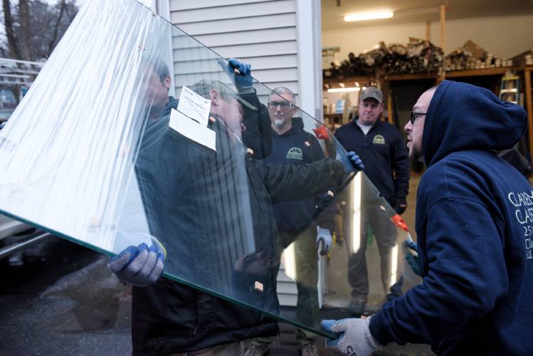 Dartagnan Velez, right, helps Roger Rumrill, left, carry a heavy piece of glass while unloading a delivery truck at Claremont Glassworks in Claremont, N.H., on Thursday, Dec. 28, 2023. Their co-workers Jonas Steele, obscured at back left, Shawn Eitapence, back middle, and Matt Steele, back left, stand by. (Valley News - James M. Patterson) Copyright Valley News. May not be reprinted or used online without permission. Send requests to permission@vnews.com.