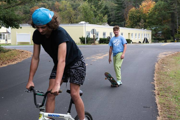Friends Cole GIlbert, 14, left, and Dominic Caicedo, 14, right, pass by the former Brookside Nursing Home in Wilder, Vt., while traveling between their homes on Tuesday, Oct. 10, 2023. The building, vacant since 2017, has been purchased by real estate firm 12 Tremont Street, managed by Tim Sidore, and is getting a paint job by Mike Davidson's property management firm Ledgeworks. (Valley News - James M. Patterson) Copyright Valley News. May not be reprinted or used online without permission. Send requests to permission@vnews.com.