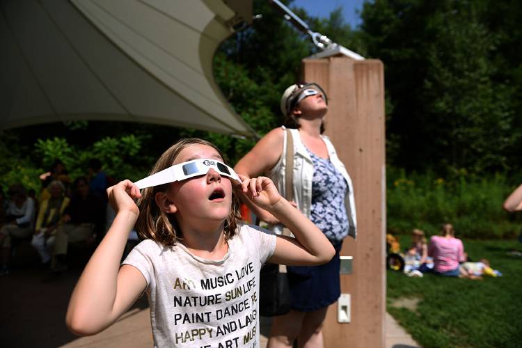Ella Dahlstrom,8, of Hartford, Vt., and Becca Girrell, of Lebanon, N.H. view the solar eclispe at the Montshire Museum of Science, in Norwich, Vt., on Aug. 21, 2017. About 1,300 people came to the museum to see the eclispe. (Valley News - Jennifer Hauck) Copyright Valley News. May not be reprinted or used online without permission. Send requests to permission@vnews.com.