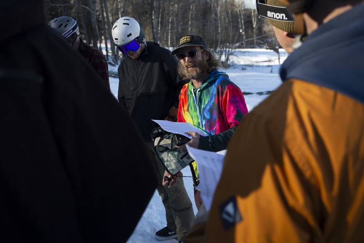 Hartford head coach John-O Mitchell, center, gives coaches a rundown of the days events before a snowboard meet at Whaleback Mountain in Enfield, N.H., on Tuesday, Feb. 6, 2024. Mitchell started Hartford’s snowboarding program four years ago and this was the team’s first time hosting a meet. (Valley News / Report For America - Alex Driehaus) Copyright Valley News. May not be reprinted or used online without permission. Send requests to permission@vnews.com.