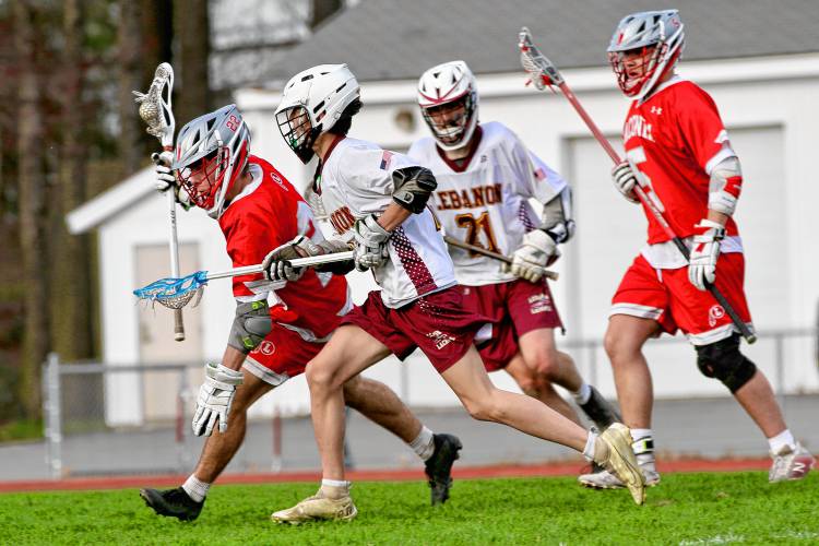 Laconia High's Brody Rollins, left, holds off Lebanon's V.J. Sites during the NHIAA Division III teams' clash at Henry Emerton Field on April 17, 2024, in Lebanon, N.H. Laconia's Alex Richardson (5) and Lebanon's Benji Madory are in the background. Laconia won, 8-2. (Valley News - Tris Wykes) Copyright Valley News. May not be reprinted or used online without permission. Send requests to permission@vnews.com. 