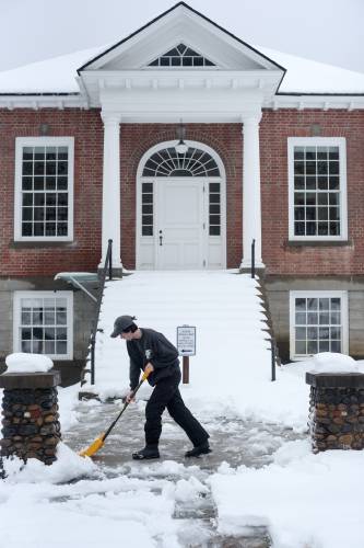 Royalton Memorial Library Director Lu Aubin shovels the sidewalk in front of the library in South Royalton, Vt., on Wednesday, Jan. 10, 2024. A large regional storm brought snow late on Tuesday that turned to rain overnight. (Valley News - James M. Patterson) Copyright Valley News. May not be reprinted or used online without permission. Send requests to permission@vnews.com.