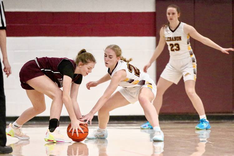 Timberlane High's Cecilia Penny, left, and Lebanon's Summer Crowell reach for the ball during their NHIAA Division II teams' Feb. 15, 2024, game in Lebanon, N.H. Nina Ellington (23) looks on. Timberlane won, 47-39, in overtime. (Valley News - Tris Wykes) Copyright Valley News. May not be reprinted or used online without permission.