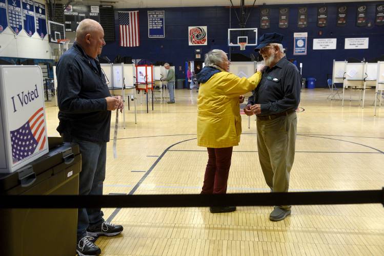 Hartford Gayle Ottmann says goodbye to poll worker Ken Baldwin after slipping her ballot into the voting machine in White River Junction, Vt., on Monday, April 15, 2024. Voters in town passed the school budget and a bond for building repairs. On the left is poll worker Mike Morris. (Valley News - Jennifer Hauck) Copyright Valley News. May not be reprinted or used online without permission. Send requests to permission@vnews.com.