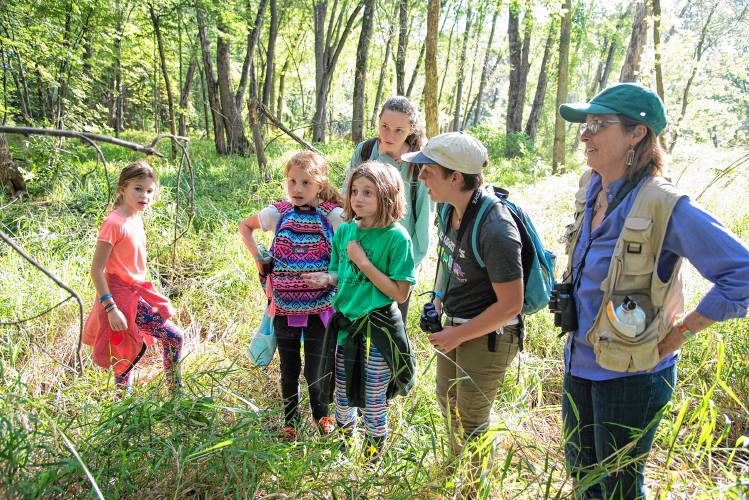 Professor Trish O’Kane and participants in her course, “Birding to Change the World,” spot a spider in the forest at Derway Island in 2016. (University of Vermont - Joshua Brown)