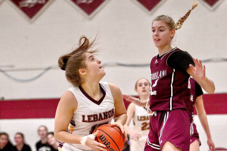 Lebanon High's Drew Kantor, left, looks past Timberlane's Ella Lampron and towards the rim during the NHIAA Division II teams' Feb. 15, 2024, Timberlane won, 47-37, in overtime. (Valley News - Tris Wykes) Copyright Valley News. May not be reprinted or used online without permission.