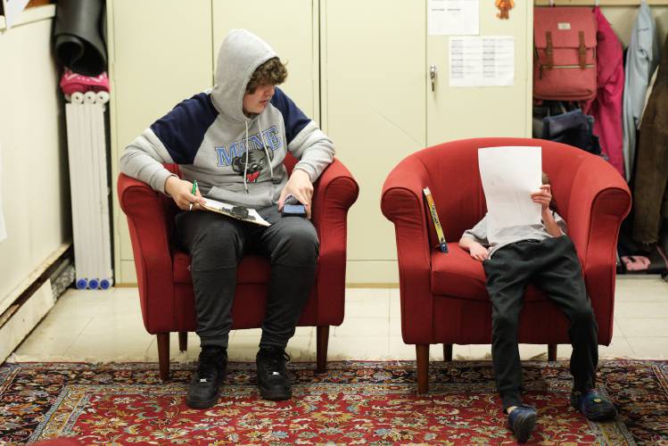 Michael Martin, 16, of Claremont, left, settles in to take a practice General Educational Development algebra test as Kain Rothbart, 8, of Newport, right, looks over a worksheet about cows during a core skills work period at Micah Studios in the basement of Epiphany Episcopal Church in Newport, N.H., on Monday, April 15, 2024. Micah Studios is an “individualized learning” center that receives tuition through New Hampshire’s Education Freedom Accounts and state scholarships. (Valley News - James M. Patterson) Copyright Valley News. May not be reprinted or used online without permission. Send requests to permission@vnews.com.
