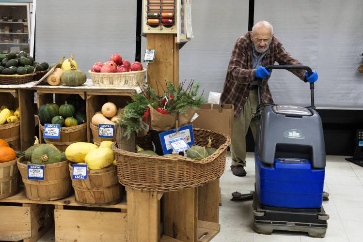 Bob Stange, 84, of White River Junction, runs a floor cleaner during his early morning shift as a custodian at the Upper Valley Food Co-op in White River Junction, Vt., on Wednesday, Dec. 6, 2023. “I walk a mile a night,” said Stange. With the apartment where they have lived for 16 years under contract to be sold, Stange and his wife, Cindyanne Packard-Stange, are preparing to move, and because of Stange’s income from the six-day-a-week, part-time job, they are not eligible for housing subsidies. (Valley News - James M. Patterson) Copyright Valley News. May not be reprinted or used online without permission. Send requests to permission@vnews.com.