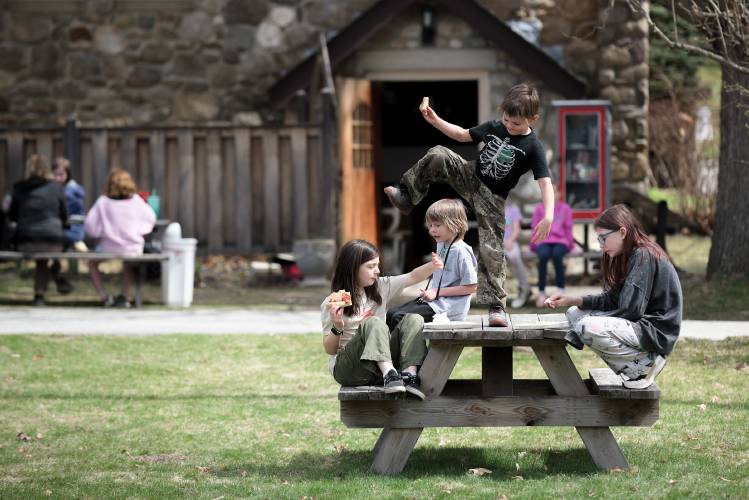 Hunter Pitts climbs on the picnic table outside Epiphany Episcopal Church in Newport, N.H., while having lunch with fellow Micah Studios students, from left, Miriam Breisch, 10, Kain Rothbart, 8, and Cece Pitts, 11, on Monday, April 15, 2024. (Valley News - James M. Patterson) Copyright Valley News. May not be reprinted or used online without permission. Send requests to permission@vnews.com.