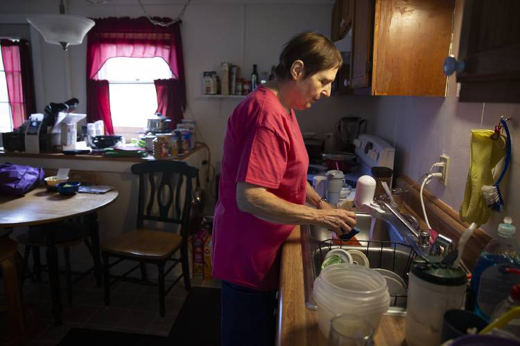 Joan Ilves, 75, of Charlestown, N.H., a personal caregiver with Ascentria Care Alliance, washes dishes at her client Thomas Kangas’s home in Charlestown on Wednesday, August 16, 2023. Ilves helps Kangas with a variety of tasks, including household chores, making sure he takes his medication and transporting him to and from appointments. (Valley News / Report For America - Alex Driehaus) Copyright Valley News. May not be reprinted or used online without permission. Send requests to permission@vnews.com.