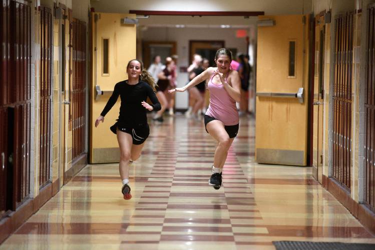 Towards the end of their lacrosse practice, players Norah Burns, left, and Savannah Lindsley sprint down the hall at Lebanon High School on Wednesday, March 27, 2024, in Lebanon, N.H. With fields covered in snow, athletes are practicing in the school. (Valley News - Jennifer Hauck) Copyright Valley News. May not be reprinted or used online without permission. Send requests to permission@vnews.com.