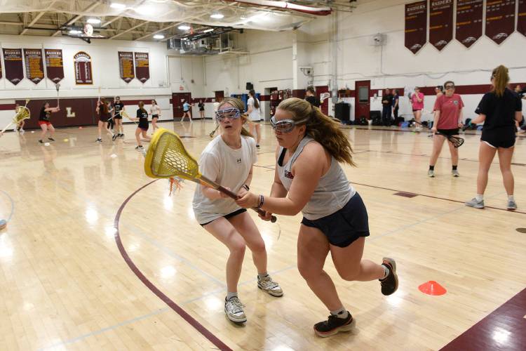 Lebanon lacrosse players Harper Rancourt and Izzy Caffrey practice their defense in the school gym on Wednesday, March 27, 2024, in Lebanon, N.H. Before the last snowfall the team was able to practice outside. They now share the gym with other spring sports athletes. (Valley News - Jennifer Hauck) Copyright Valley News. May not be reprinted or used online without permission. Send requests to permission@vnews.com.