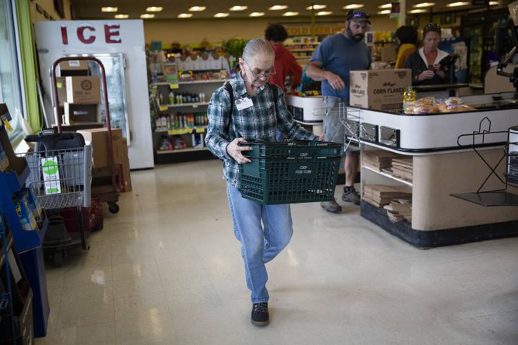 Evelyn Adams, 69, of White River Junction, Vt., returns shopping baskets to the store entrance at the Co-op Food Store in White River Junction on Friday, August 25, 2023. Adams typically works two or three days per week and said that several of her coworkers are similar in age or older. (Valley News / Report For America - Alex Driehaus) Copyright Valley News. May not be reprinted or used online without permission. Send requests to permission@vnews.com.