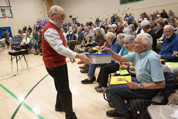 Vice Moderator Bill Waste collects paper ballots for a petitioned article that would have required the Selectboard to perform a “Full Statistical Revaluation” for the tax year 2024 to update appraised property values to more accurately reflect the current market during Town Meeting at the Lyme School Community Gymnasium in Lyme, N.H., on Tuesday, March 21, 2023. Voters rejected the article, but approved all others on the warrant. (Valley News / Report For America - Alex Driehaus) Copyright Valley News. May not be reprinted or used online without permission. Send requests to permission@vnews.com.