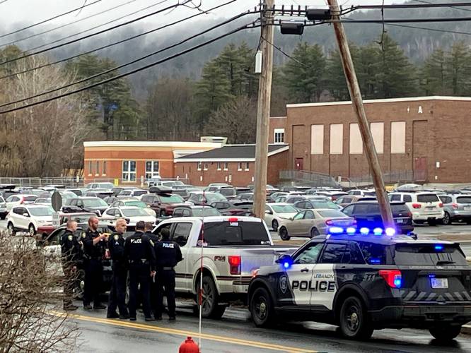 Lebanon police officers surround a white Ford pickup outside Lebanon High School and Hanover Street School on Friday afternoon. The schools were placed on lockdown just after dismissal on Friday afternoon. (Valley News- James M. Patterson)
