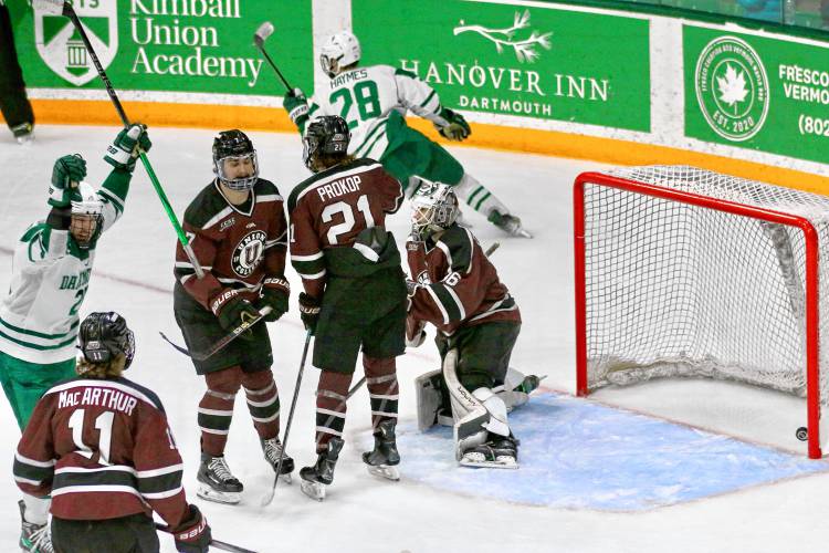 Dartmouth College's Luke Haymes (28) curves into the corner after scoring the winning goal against Union during an ECAC quarterfinal game on March 16, 2024, at Thompson Arena in Hanover, N.H. The Big Green's Cooper Flinton celebrates at left. Dartmouth won, 4-2, to sweep the best-of-three series and advance to the semifinals in Lake Placid, N.Y. Valley News - Tris Wykes) Copyright Valley News. May not be reprinted or used online without permission. 