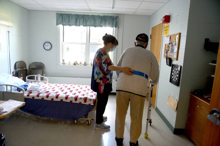 Licensed nursing assistant Rhonda Benjamin helps resident Fred Page, 86, back to his room after lunch at the Grafton County Nursing Home in North Haverhill, N.H. on Thursday, Sept. 14, 2023.
 (Valley News - Jennifer Hauck) Copyright Valley News. May not be reprinted or used online without permission. Send requests to permission@vnews.com.