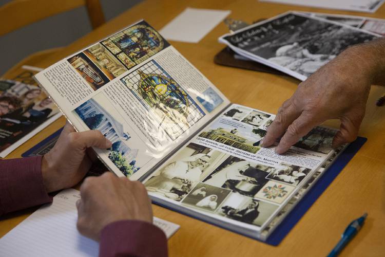Howard Hoke, left, president of Echo Communications, looks through a mockup of a book commemorating the history of the Shrine of La Salette in Enfield compiled by John Markowitz, right, of Enfield, N.H., during a production meeting at Echo Communications in New London, N.H., on Tuesday, Aug. 29, 2023. The pair talked about the changes the community has experienced over the years that are chronicled in the book, noting that the closing of the shrine didn’t feel like an ending. “The sacred nature of the place is not going to change one bit,” Hoke said. (Valley News / Report For America - Alex Driehaus) Copyright Valley News. May not be reprinted or used online without permission. Send requests to permission@vnews.com.