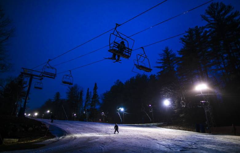 Riders and a lone skier brave the light rain at sunset during night skiing at Pats Peak on Thursday, March 24, 2022. The last day of operations at the ski area is Sunday.