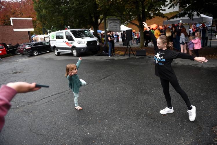 Jayna McWhorter, of Cornish, N.H., plays music on her phone for her daughter Julianna McWhorter, 3, left, and Chiara Moriglioni, 9, of Springfield, Vt., during the Autumn Moon Festival on Friday, Oct., 6, 2023, in Windsor, Vt. Moriglioni dances with Dreams in Motion, her group had just performed for a crowd at the festival. Taken with the dancers, Julianna McWhorter learns a few steps from Moriglioni. (Valley News - Jennifer Hauck) Copyright Valley News. May not be reprinted or used online without permission. Send requests to permission@vnews.com.