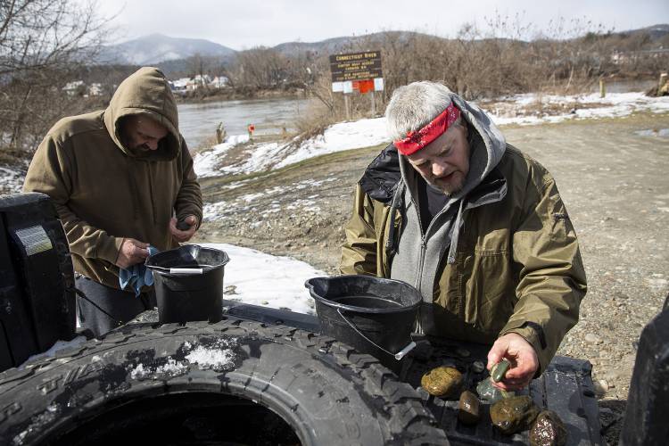 Dave Patten, left, and Eric Bastian, both of Claremont, N.H., clean rocks they collected from the Connecticut River boat launch in Cornish, N.H., on Monday, March 11, 2024. Bastian, who started collecting rocks with his father as a child and now gives them to his sister to make jewelry, said he loves to find interesting colors and marvels at how many years it takes to compress the layers of sediment. “People don’t notice nature anymore,” he said. (Valley News / Report For America - Alex Driehaus) Copyright Valley News. May not be reprinted or used online without permission. Send requests to permission@vnews.com.