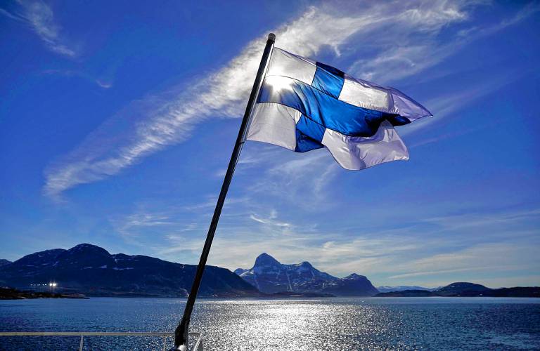 Finland's flag flies aboard the Finnish icebreaker MSV Nordica as it arrives into Nuuk, Greenland, in 2017. According to the international World Happiness Report, Finland is the happiest country in the world in 2024. (AP Photo/David Goldman)