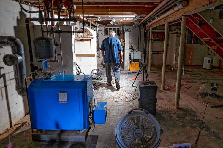 Jerry Williams inspects fans and a heater drying out the basement of his flood-damaged home in Johnson, Vt., on Wednesday, July 27, 2023. (VtDigger - Glenn Russell)
