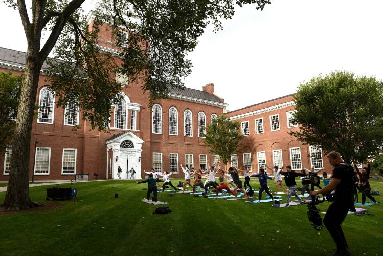Dartmouth College students and faculty follow yoga instructor Laura Beth 