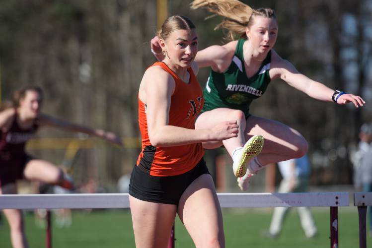 Maddox Lovely, of Newport, left, sprints to the finish as Sydney Schoenbeck, of Rivendell clears the last of the 100 meter hurdles in Lebanon, N.H., on Tuesday, April 24, 2024. They finished first and second with times of  16.37 seconds and 16.67 seconds respectively. (Valley News - James M. Patterson) Copyright Valley News. May not be reprinted or used online without permission. Send requests to permission@vnews.com.