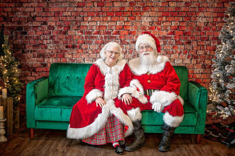 Marty and Jack Candon, dressed as Mrs. and Santa Claus, sit for a photograph on a day families had scheduled photographs with Santa in Dec. 2022. (Cara Dyke photograph)