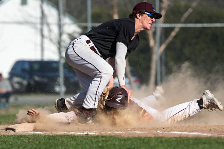 Ryan Lundrigan, of Lebanon, slides safely into third base before Finn Ware, of Hanover, can locate the ball in Lebanon, N.H., on Friday, April 26, 2024. Hanover won 7-5 in eight innings. (Valley News - James M. Patterson) Copyright Valley News. May not be reprinted or used online without permission. Send requests to permission@vnews.com.