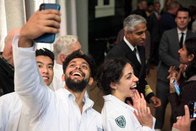 First-year students in Dartmouth College's Geisel School of Medicine, from left, Matthew Chen, David Abraham and Rawan Bresselsmith, take photos with Surgeon General, Vice Admiral Vivek Murthy in the background following a roundtable on mental health at Leede Arena in Hanover, N.H., on Thursday, Sept. 28, 2023. (Valley News - James M. Patterson) Copyright Valley News. May not be reprinted or used online without permission. Send requests to permission@vnews.com.