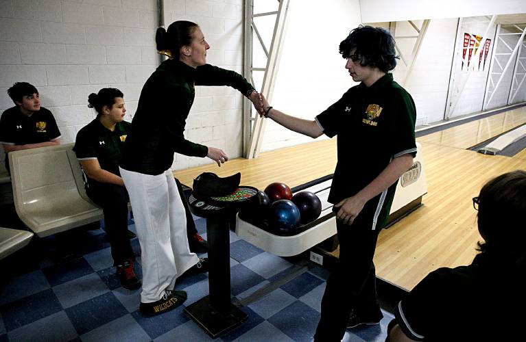 While looking at the scoring, White River Valley bowling coach Robynn Martin congratulates Exzavier Stover on his roll during their qualifying round against Fair Haven, Hartford and Windsor in Claremont, N.H., on Feb. 4, 2023. Wildcat teammates Connor Hurdle, left, Andrew Vanesse and Hannah Vanesse, right, wait their turn. (Valley News - Geoff Hansen) Copyright Valley News. May not be reprinted or used online without permission. Send requests to permission@vnews.com.