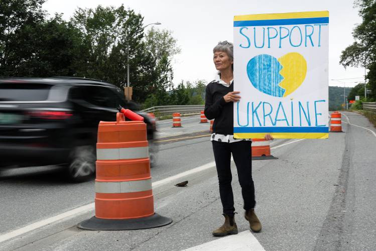 Joette Hayashigawa, of Thetford, continues her weekly vigil, begun in March, 2022, standing for two hours every Friday on Main Street in Norwich, Vt., holding her “Support Ukraine” sign as commuters cross the Ledyard Bridge on August 25, 2023. “It’s something I just feel like I have to do,” she said. “I don’t know if it’s helping anything.” She fears support will wane as the conflict drags on, but said she makes connections with people who honk and wave. “It makes me think people know the difference between right and wrong.” (Valley News - James M. Patterson) Copyright Valley News. May not be reprinted or used online without permission. Send requests to permission@vnews.com.