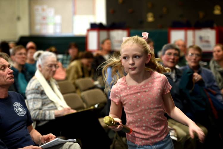 With microphone in hand, Braelynn Parson, 11, runs to the next Newbury resident who wants to speak at Town Meeting on Tuesday, March 5, 2024, in Newbury, Vt. Parson's father is on the selectboard – she said he volunteered her for the job of shepherding the mic.(Valley News - Jennifer Hauck) Copyright Valley News. May not be reprinted or used online without permission. Send requests to permission@vnews.com.