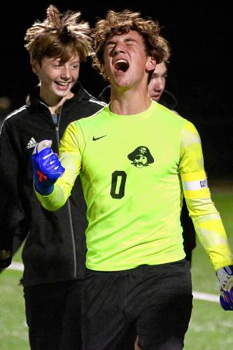 Hanover High soccer goalkeeper Ty Nolon screams in exultation after his NHIAA Division I team defeated Windham, 3-0, during the playoff semifinals on Nov. 2, 2022, in Exeter, N.H. Behind Nolon are Roan Palm, left, and Ian Smith. (Valley News - Tris Wykes) Copyright Valley News. May not be reprinted or used online without permission. 