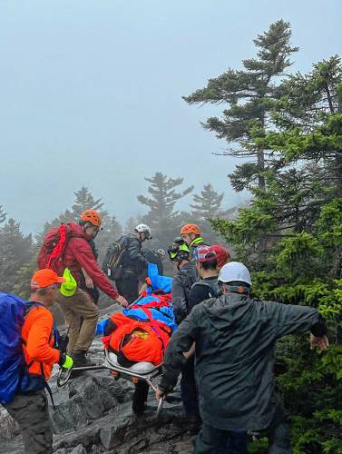 Patrick Tyler, 70, of Hollis, N.H., is carried down from Mount Cube in Orford, N.H., by rescue personnel on Monday, Aug. 7, 2023. Tyler's spouse called 911 after he slipped and struck his head. (NH Fish and Game photograph)